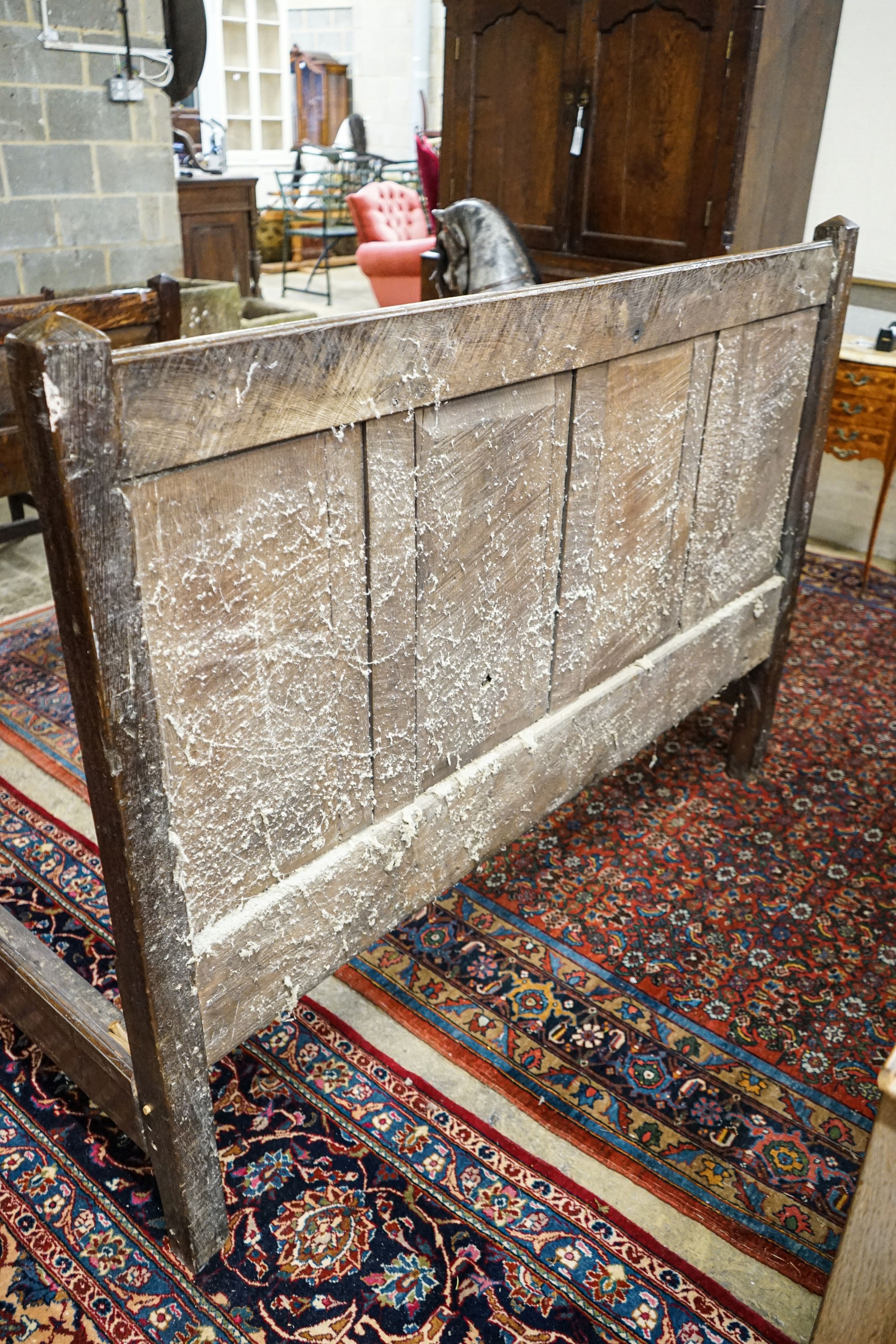 A 17th century style panelled oak bedstead, width 158cm, length 208cm